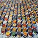 Detailed depiction of a meticulously laid out table adorned with numerous cans of soup. Each can displays labels of various hues and patterns, signifying the diversity in flavors and brands they represent. The cans are carefully arranged in an aesthetically pleasing manner, with the colors of the labels creating a vibrant visual feast. The presentation is enticing, almost encouraging the viewer to step forward and choose their favorite flavor.